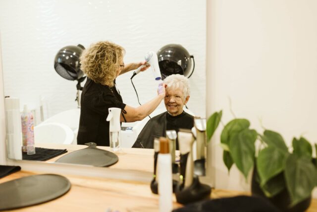 Resident smiles while getting her hair done at the Clearwater Spa at The Hawthorn at Elim Village Garrison Crossing